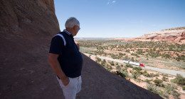 My father watches traffic go by on the base of Wilson's Arch